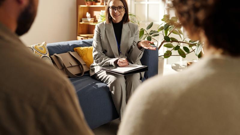 Professional adult conversing with two other adults