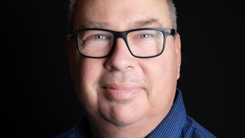 Caucasian man with brown hair wearing glasses