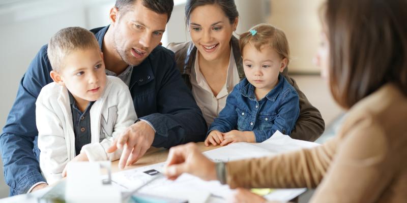 A family of four meeting with a social services worker