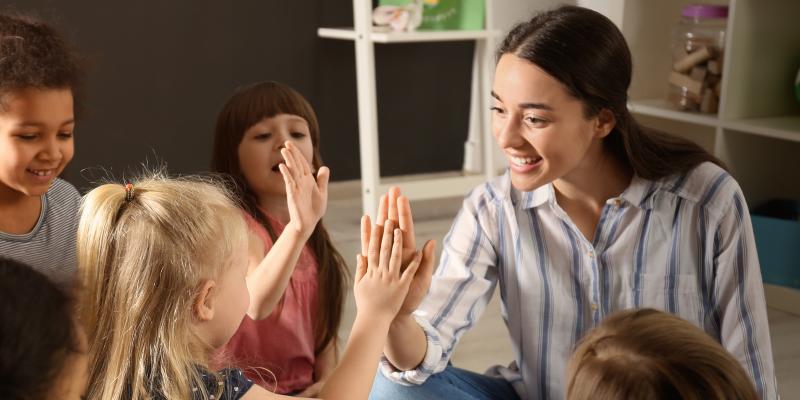 Female teacher with multiple young students