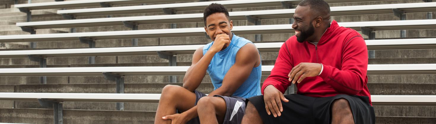 Youth with adult sitting in empty stadium