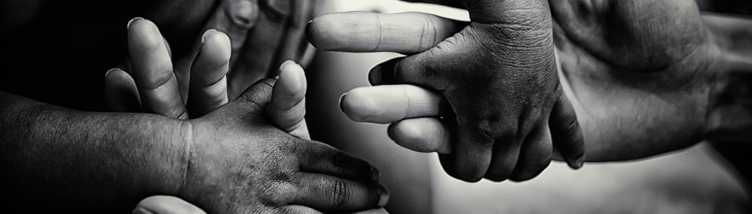 B&W photo of child's hands in adult's