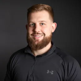White male with dark red hair and beard wearing black shirt.